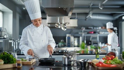 Restaurant Kitchen: Black Female Chef Cooking Delicious and Traditional Authentic Food, Uses Oil on...