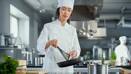 Restaurant Kitchen: Portrait of Asian Female Chef Stirs Her Favourite most Flavourful Dish, Smiles....