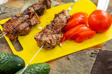 Top down view beef meat on steel skewers grilling on brazier