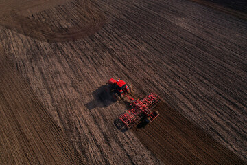 Tractor with cultivator plowing field. Tractor disk harrow on ploughing a soil. Planting in...