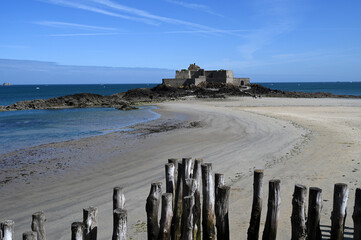 Plage de l'Eventail et Fort National de Saint-Malo avec des brise-lames en bois au premier plan