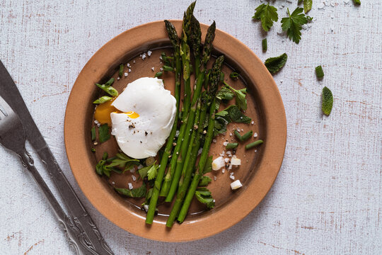 Healthy breakfast with asparagus and  poached egg on rustic table