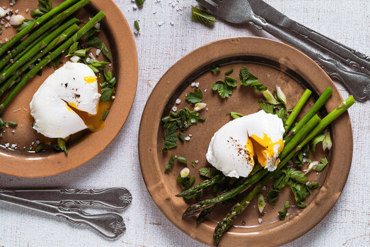 Healthy breakfast with asparagus and  poached egg on rustic table