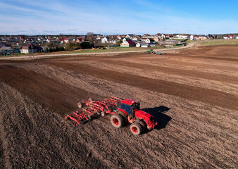 Tractor with cultivator plowing field. Tractor disk harrow on ploughing a soil. Planting in...