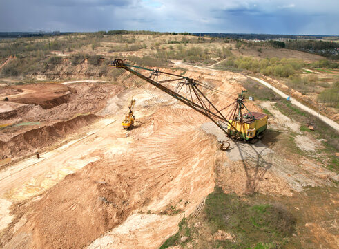 Walking dragline excavator in open pit on dolomite development. Big muskie in open-pit mining. Mining clay in quarry. Anthropogenic landscape with mountains in open cast mine. Limestone mining. .
