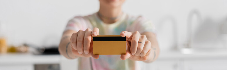 selective focus of credit card in hands of cropped woman on blurred background, banner