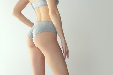 Cropped image of fit, tonned female body, buttocks in comfortable cotton underwear isolated over...