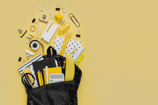 Opened School Backpack With Stationery On Yellow Background. Concept Back To School. School Supplies With Black School Bag.