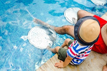 father and son playing in pool