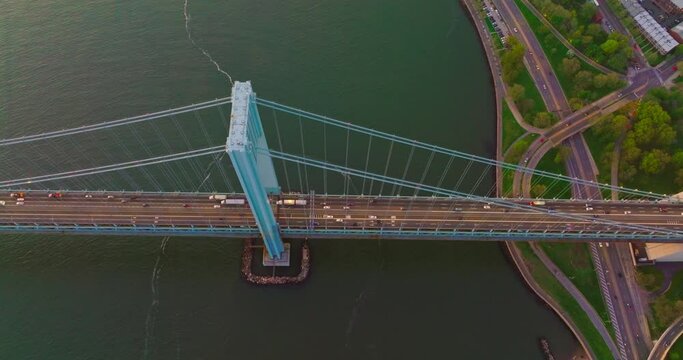 The Bronx-Whitestone bridge over the East River. Flying high above the bridge construction with cars passing through it.
