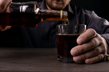 A man pours alcohol into a glass.