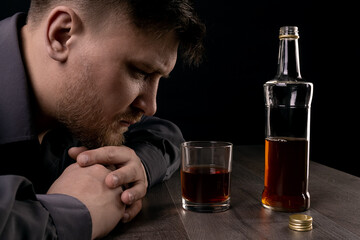Lonely man drinks alcohol in the dark.