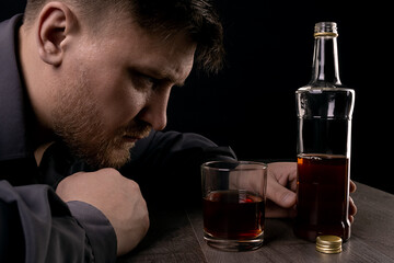 Lonely man drinks alcohol in the dark.