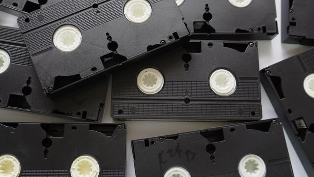Woman stacking VHS cassette tapes one at a time