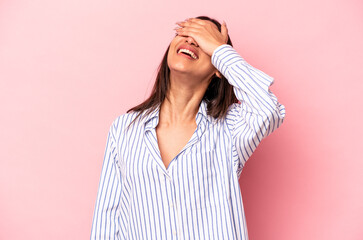 Young hispanic woman isolated on pink background laughs joyfully keeping hands on head. Happiness concept.