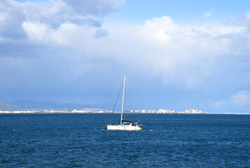 Yacht with a sail. Sailboat at sea on sailing on waves. Yachtsman during training on a sailboat. Skiff and Sailboat in sea near the Spanish coast. Sail sport in Yacht club. Sail boat on waves in sea.