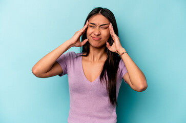 Fototapeta premium Young hispanic woman isolated on blue background touching temples and having headache.