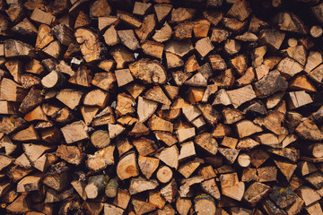 Stacked firewood close-up. Firewood storage close up. Stocks of wooden logs close-up. Chopping wood. Logging in the village. Rustic lifestyle. Woodpile with firewood full frame image. Wooden texture.

