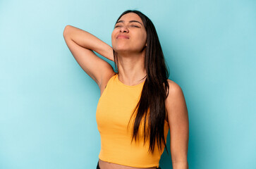 Young hispanic woman isolated on blue background massaging elbow, suffering after a bad movement.