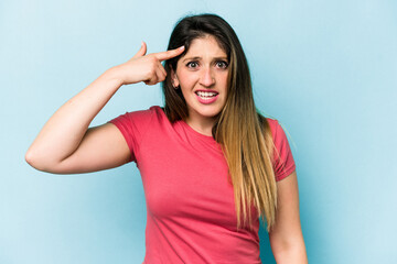 Young caucasian woman isolated on blue background showing a disappointment gesture with forefinger.