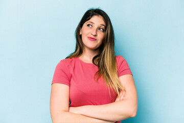 Young caucasian woman isolated on blue background dreaming of achieving goals and purposes