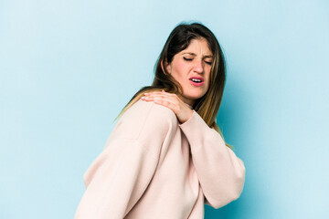 Young caucasian woman isolated on blue background having a shoulder pain.
