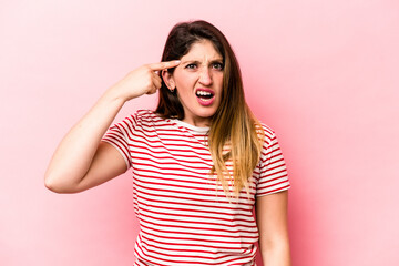 Young caucasian woman isolated on pink background showing a disappointment gesture with forefinger.