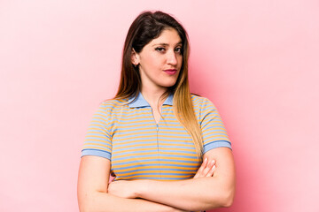 Fototapeta premium Young caucasian woman isolated on pink background suspicious, uncertain, examining you.