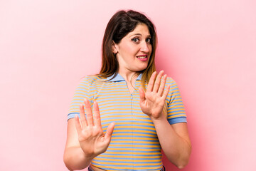 Young caucasian woman isolated on pink background rejecting someone showing a gesture of disgust.