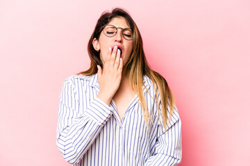 Young caucasian woman isolated on pink background yawning showing a tired gesture covering mouth with hand.