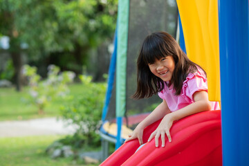 Fototapeta na wymiar Asian girls playing slides, play ground