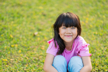 Obraz premium happy girl sitting on the grass, play ground