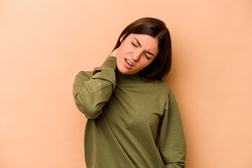 Young hispanic woman isolated on beige background suffering neck pain due to sedentary lifestyle.