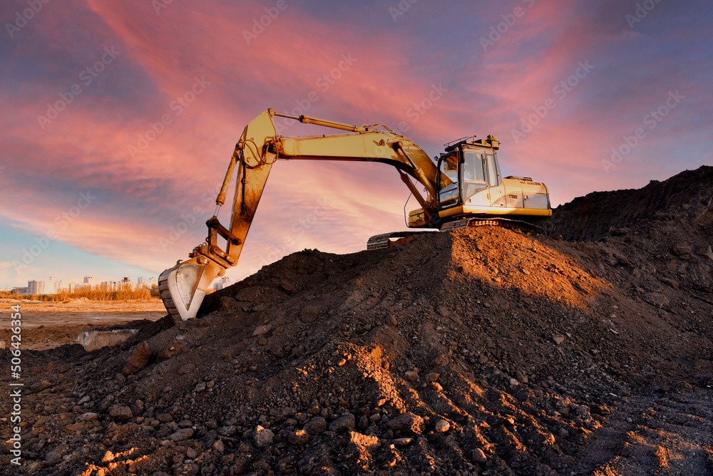 Poster excavator on earthmoving on sunset background. loader at open pit mining. excavator digs gravel in q