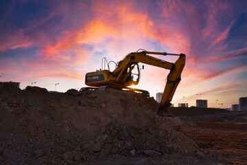Excavator on earthmoving on sunset background. Loader at open pit mining. Excavator digs gravel in quarry. Heavy construction equipment on excavation. Earth mover ar construction site. Open-pit mine.