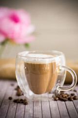 A cup of hot coffee with milk with coffee beans