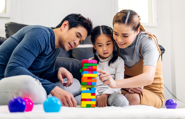 Portrait of enjoy happy love asian family father and mother with little asian girl smiling activity learn and skill brain training play with toy build wooden blocks board education game at home