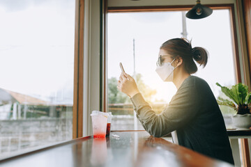 a business woman sitting alone working on a mobile phone and a glass of water on the side