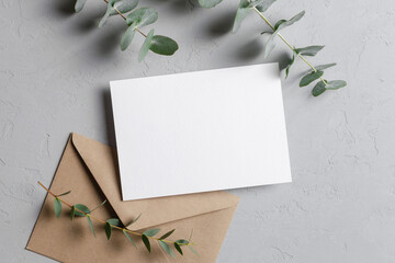 Blank invitation or greeting card mockup with envelope and eucalyptus plant decoration