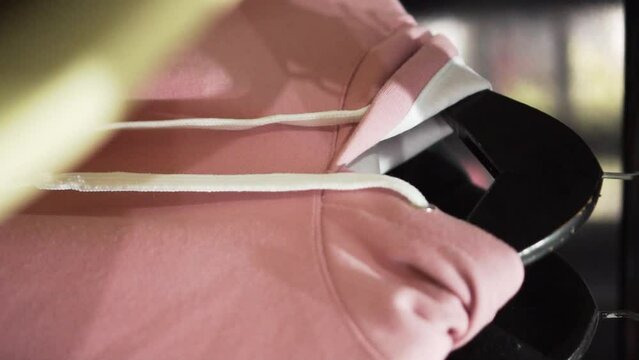 Close up of a pink fashion hoodie on a hanger made of cotton