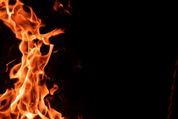 Strong orange campfire flame isolated on black night background with copyspace