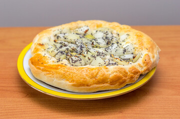 Polish onion cake Cebularz. Originating from Jewish cuisine, is a wheat dough pancake, with a diameter of 15-20 cm, topped with diced onion and poppy seed.
