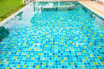 Macro from Swimming pool with clear blue water in a garden area, surrounded by plants