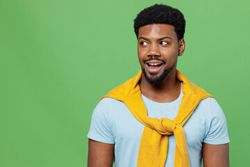 Young impressed amazed man of African American ethnicity 20s wear blue t-shirt look aside on workspace area mock up staring isolated on plain green background studio portrait People lifestyle concept