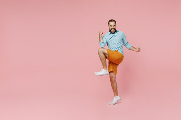 Fototapeta na wymiar Full body young excited man 20s wear classic blue shirt doing winner gesture celebrate clenching fists say yes isolated on plain pastel light pink background studio portrait. People lifestyle concept.