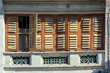 Detail of brown rectangular wooden windows of an old vintage shop house in the heritage town of Penang.
