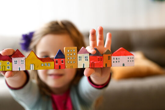Housing affordability with a family concept shown with child holding blocks of coloured homes
