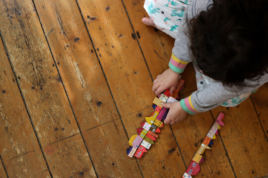 Housing affordability with a family concept shown with child playing with blocks of coloured homes