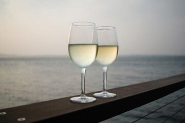 close up shot of two wine glasses with ocean view