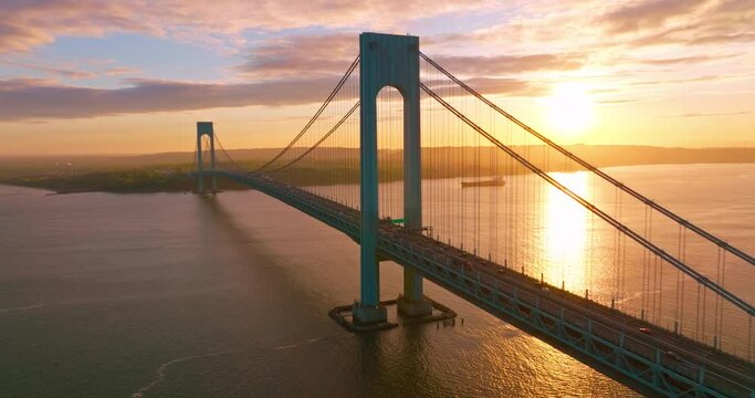 Splendid view of Whitestone bridge over the East River. Fantastic sight of the bridge at the backdrop of setting sun and pink clouds.